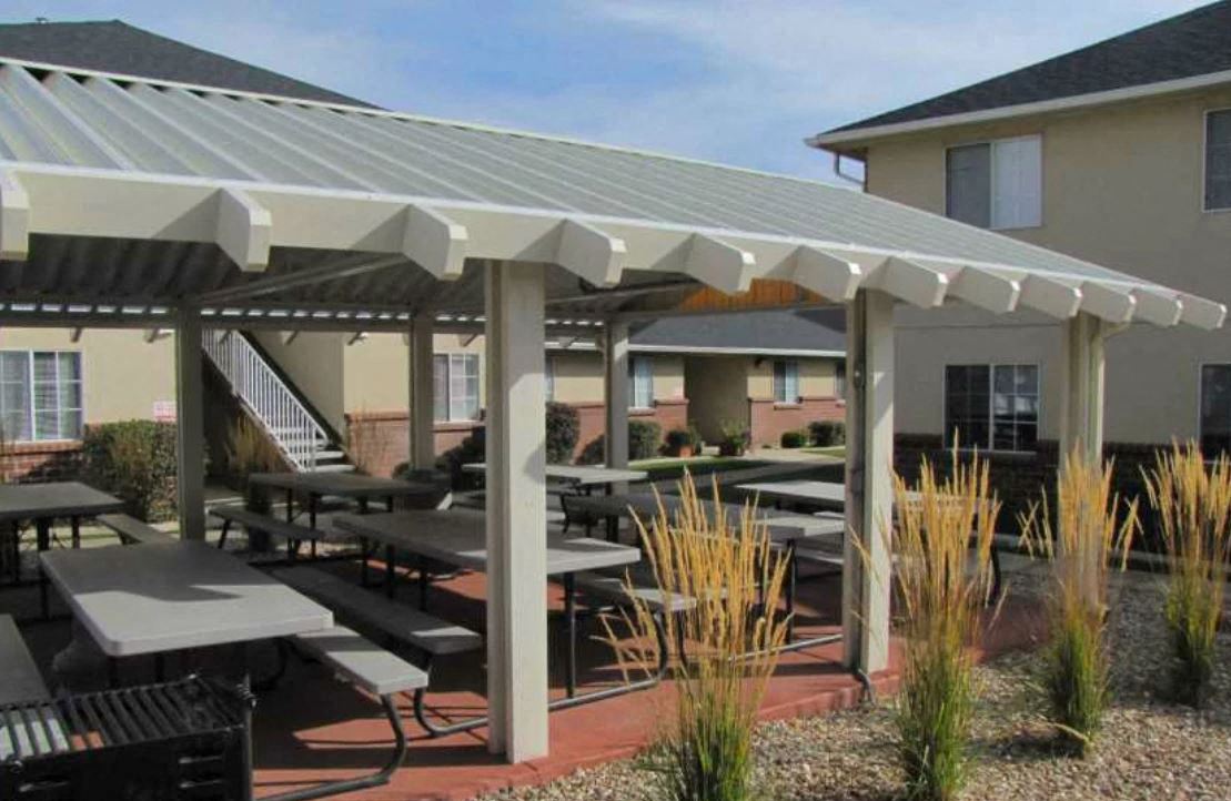 a patio with tables and umbrellas in front of a building